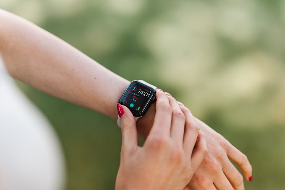 Woman adjusting smartwatch with manicured nails outdoors, focusing on fitness app.