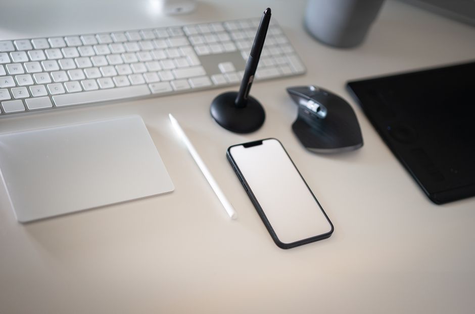 Clean and modern workspace featuring keyboard, smartphone, and wireless mouse with minimalistic design.